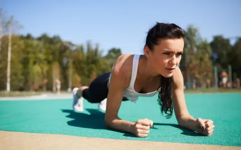 Kobieta wykonuje plank, idealne ćwiczenie na trening core dla początkujących.