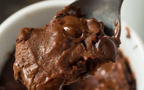 Łyżka z porcją pysznej, pieczonej owsianki brownie z roztopioną czekoladą.