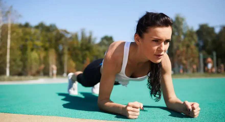 Kobieta wykonuje plank, idealne ćwiczenie na trening core dla początkujących.