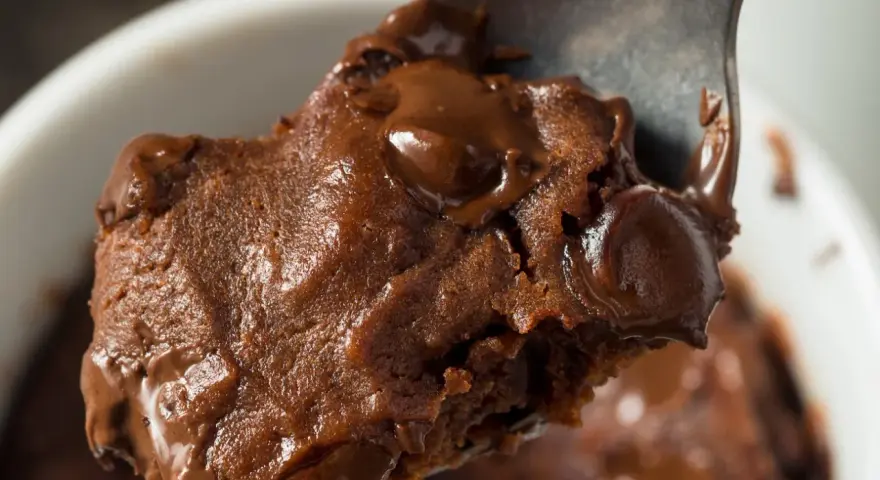 Łyżka z porcją pysznej, pieczonej owsianki brownie z roztopioną czekoladą.