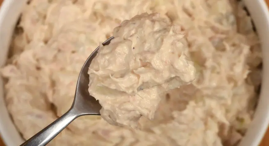 Łyżka pełna kremowej pasty z tuńczyka, gotowa do podania. Idealna na kanapki lub jako dodatek.