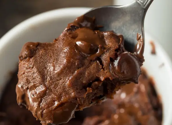 Łyżka z porcją pysznej, pieczonej owsianki brownie z roztopioną czekoladą.