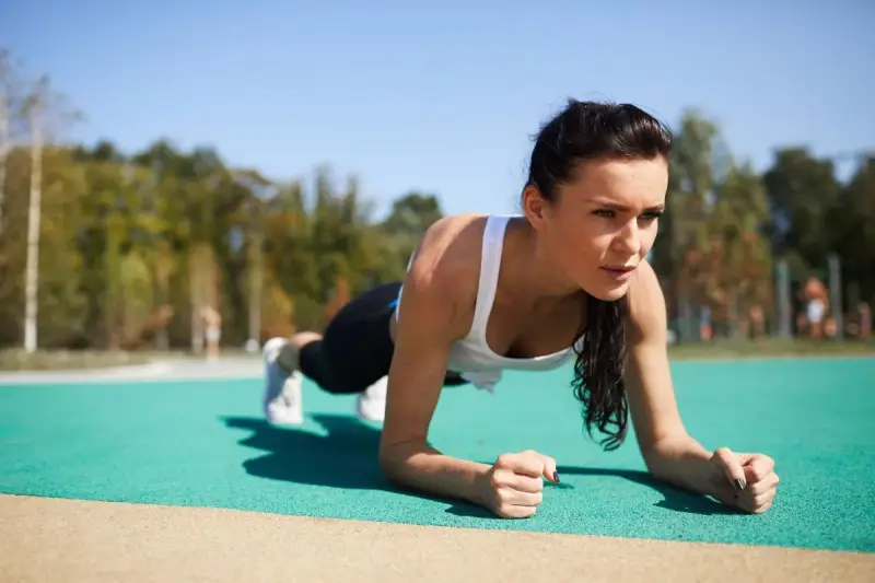 Kobieta wykonuje plank, idealne ćwiczenie na trening core dla początkujących.